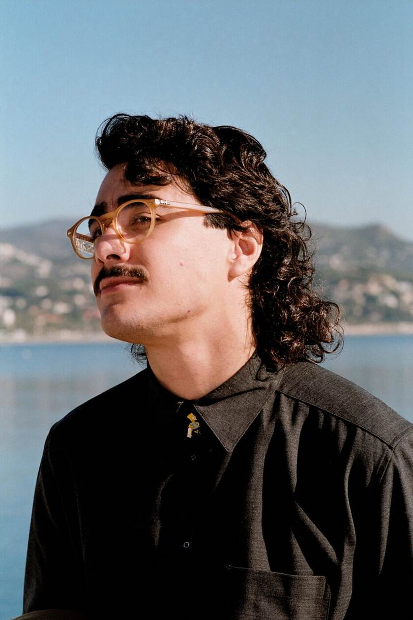 Uomo con il mullet in camicia dal collo aperto, stile mediterraneo